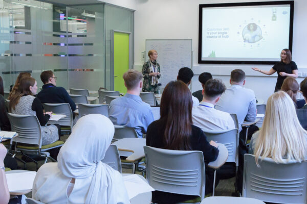 Salesforce Senior Manager Rhona Wallace briefs the students and judges watched by colleagues.